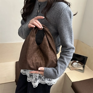 Sac hobo imprimé léopard marron avec poignée nouée porté par un mannequin en intérieur