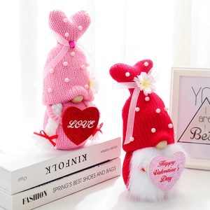 Pair of Valentine's Day knitted gnomes with hearts and pearls on books decor
