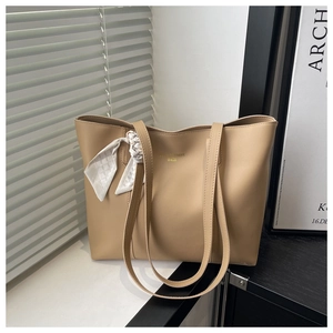 Detail of a large capacity khaki tote bag with a decorative plaid scarf and golden logo