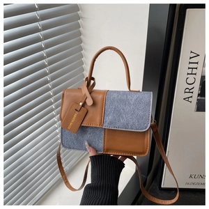 Detailed shot of retro color-block handbag with brown leather and grey suede textures