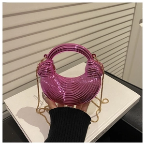Detail of rose pink acrylic crescent handbag with wave texture and gold chain strap