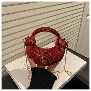 Macro shot of bright red acrylic evening bag with spiral texture and gold chain
