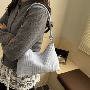 Light blue quilted shoulder tote bag with woven texture and elegant knotted shoulder strap