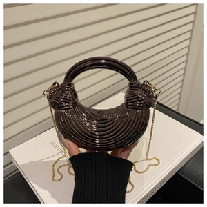 Detail of metallic crescent acrylic handbag with ripple texture and chain strap
