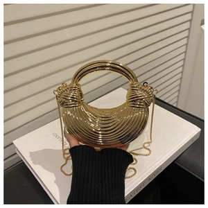 Detail of golden crescent acrylic clutch showing textured pleats and metal handle