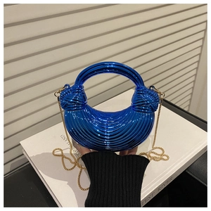 Detail view of electric blue metallic clutch bag with radial texture and gold chain strap