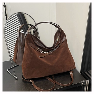 Détail du sac cabas en daim marron avec boucle métallique et fermeture éclair fluide