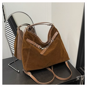 Détail du sac Hobo en daim marron foncé avec bandoulière en cuir et boucle décorative
