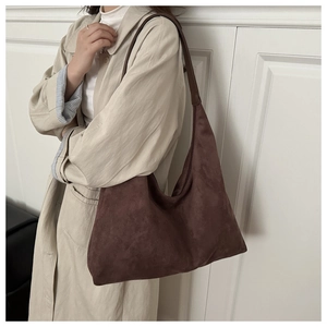 Detailed view of deep brown suede hobo bag worn on shoulder for autumn aesthetic