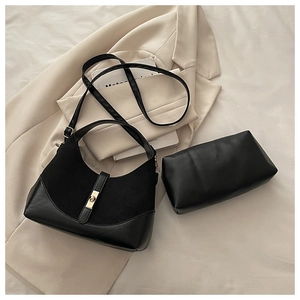 Detail view of the black contrast shell bag with golden buckle and matching clutch