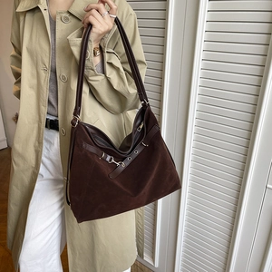 Grand sac cabas marron en velours avec détails en cuir porté par un mannequin