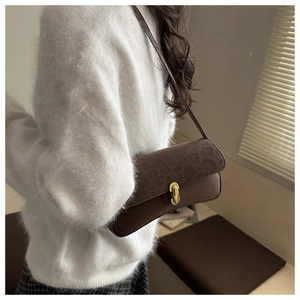 Detail der dunkelbraunen Wildleder-Unterachseltasche mit Leopardenmuster und Goldverschluss