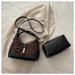 Detailed view of leopard print hobo bag set and black inner pouch on white fabric