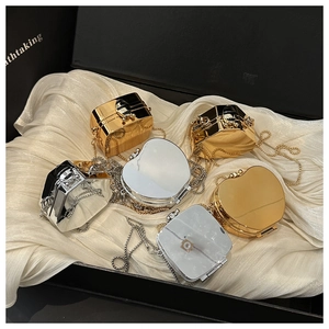 Exquisite gold and silver mirrored mini evening bags displayed on elegant silk lining