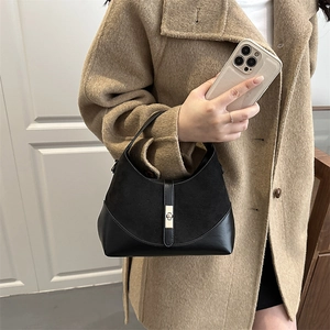 Chic black contrasting leather half-moon bag with silver metal buckle on a stylish model