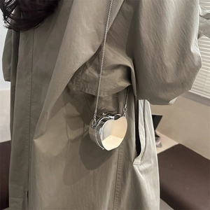 Silver heart-shaped mini crossbody bag with metal chain strap and shiny finish