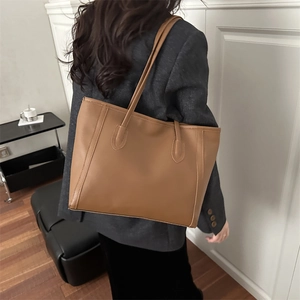 Fashionable brown large capacity tote bag for women showing a minimalist shoulder style