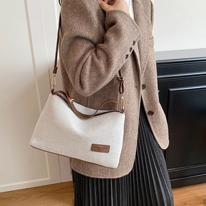 Minimalist white knit crossbody bag with brown leather trim and adjustable shoulder strap