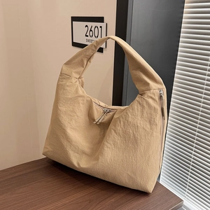 Detailed macro view of the khaki nylon tote bag featuring durable dual metal zippers