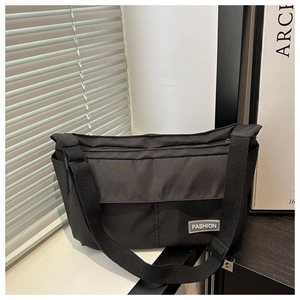 Detail of black nylon messenger bag with fashion label on modern minimalist background