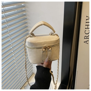 Detail of creamy white mini bag with metal double zipper and leather chain strap