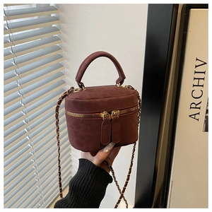 Detailed close-up of burgundy velvet mini box bag with gold metal chain and leather handle