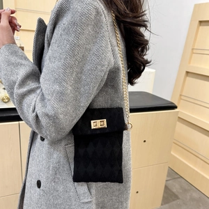 Chic black faux suede crossbody phone bag with quilted texture and gold chain strap
