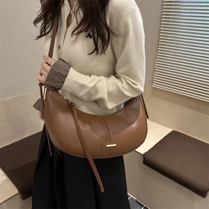 Sac bandoulière demi-lune en cuir marron avec boucle dorée au style urbain épuré