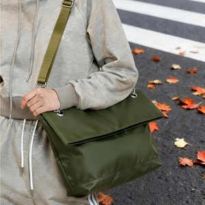 Olive green large tote bag for women with wide strap in autumn street scene
