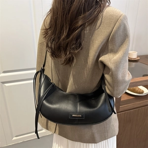 Sac hobo noir élégant avec logo en métal doré et pompon en cuir pour femmes chic