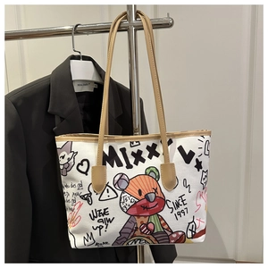 Dettaglio della borsa tote in tela con graffiti street style e manici in pelle