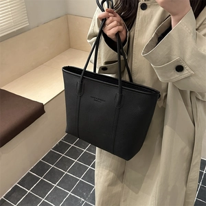 Classic black lychee pattern tote bag with shoulder straps shown on an elegant model