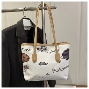 Dettaglio della borsa tote in tela bianco sporco con simpatiche illustrazioni spaziali