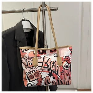 Dettaglio delle stampe graffiti stile street su una borsa tote in tela con spalline sottili