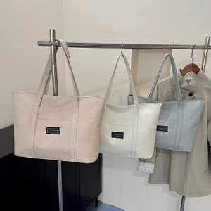 Vue détaillée de trois sacs cabas suspendus en coton et lin en beige, crème et gris