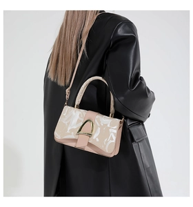 Détail du sac bandoulière rose avec imprimé lettres artistiques et boucle D dorée