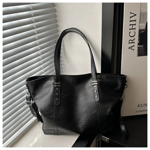 Detail showing silver star buckles and premium black PU leather texture on tote bag