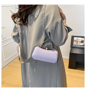 Detail of light purple sequined evening clutch bag with pearl clasp and silver chain strap