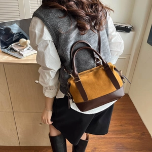 Gelbe Wildleder-Handtasche im Retro-Stil mit braunem Lederbesatz in Büroumgebung