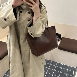 Minimalist large brown PU leather tote bag shown with model in a stylish trench coat