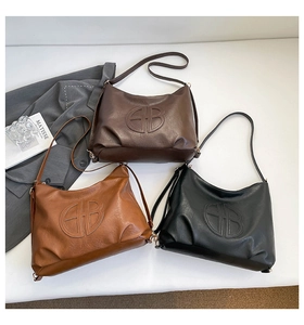 Detailed view of minimalist leather tote bags in black, brown, and caramel colors