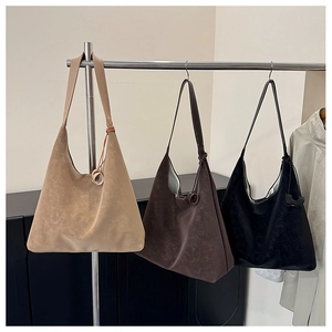 Detailed texture of minimalist tote bags in light brown, dark brown, and black suede