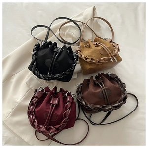 Detail of four drawstring bucket bags in suede and leather with woven circular handles