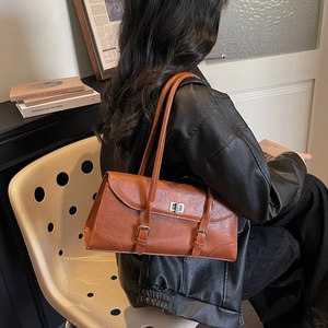 Retro brown leather shoulder bag with buckle details and elegant minimalist pillow design
