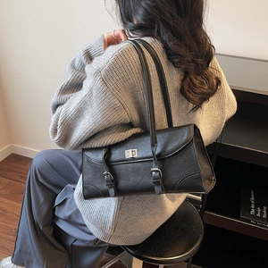 Vintage black leather pillow shoulder bag with metal turn-lock and decorative buckle straps