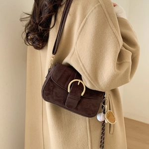 Vintage brown leather saddle bag with gold horseshoe buckle and crossbody strap for women