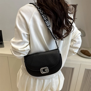 Fashionable black pebbled leather saddle bag with rhinestone G buckle and geometric strap