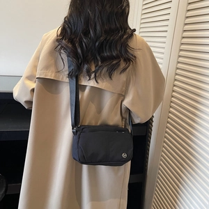 Black nylon crossbody bag with adjustable strap and metal logo for casual city wear