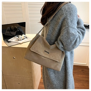 Gros plan du sac en cuir rétro kaki avec boucle argentée et détail de bandoulière chaîne