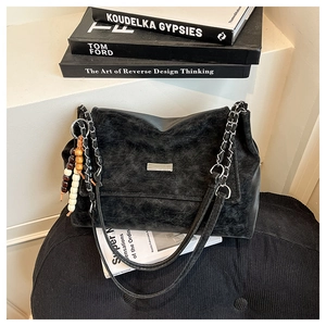 Détails d'un sac cabas vintage en cuir noir avec chaîne métallique et perles en bois